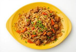 Yellow plate with meat and vegetable stir fry noodles, isolated on a white background, top view. photo