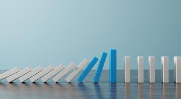 Domino effect shown with blue blocks stopping the fall of white blocks, representing intervention, solution and problem solving concept. photo