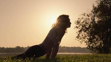An individual practices yoga at dawn by the lakeside, highlighting the peace and harmony that sun salutation poses bring, creating a mindful and tranquil atmosphere in natures beauty video