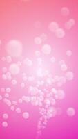 A flowing stream of smooth shiny spheres flowing towards the camera against a pink gradient background. This cute vertical motion design is full HD and a seamless loop. video
