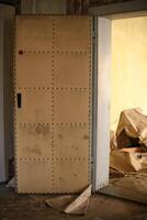 Padded door with visible wear and foot marks grime in an abandoned building photo