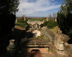 Fountain garden terrace of Roseburg in Germany with stone sculptures and trimmed hedges under a clear spring sky photo