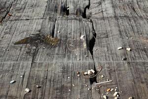 Cracked rooftop surface with scattered debris and visible damage from wear and exposure photo