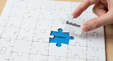 Hand places Solution puzzle piece into jigsaw with Problem written below. Conceptual image for problem solving and strategic planning. photo
