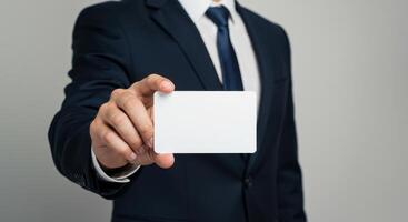 Businessman in suit holding blank card. Mockup of empty card for business message, promotion, name card, visiting card, credit card, membership card template. photo