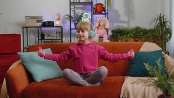 Child kid girl lifting dumbbells while doing exercises, enjoying training, listening music at home video