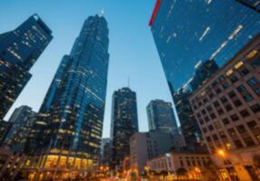 Cityscape featuring illuminated skyscrapers against a twilight sky. Urban architecture showcases a modern skyline with office buildings and commercial development at dusk. photo