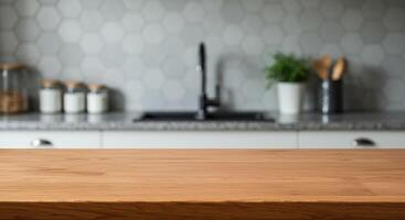 Wooden table in blurred kitchen interior with sink, plant, and utensils. Countertop surface for product display and food preparation concept. photo