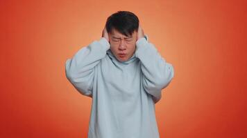 Annoyed irritated handsome man covering ears gesturing No avoiding advice ignoring noise loud voices video