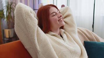 Tired lazy woman enjoy relaxing on home sofa resting napping after hard working day, closed her eyes video