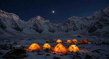 Night view of illuminated tents in snowy mountain landscape under starry sky. Adventure camp in Himalayas with climbers resting for summit climb. photo