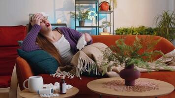 Sick ill young woman suffering from cold, allergy lying on home sofa sneezes wipes snot into napkin video