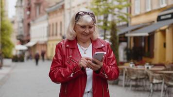 Senior woman using smartphone typing text messages looking for a way on map in mobile navigator app video