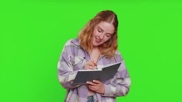 Woman making notes writing down thoughts with pen into notepad notebook diary, to do list, good idea video