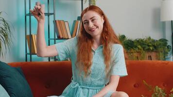 Woman real estate agent showing the keys of new home house apartment, buying or renting property video