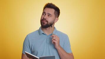 Man making notes, writing down thoughts with pen into notepad notebook diary, to do list, good idea video