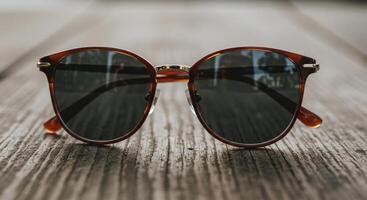 Elegant tortoiseshell sunglasses Resting on weathered wooden surface photo