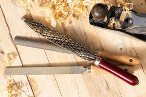 Flat lay of s Set of Rasps lying on wooden planks in a carpentry workshop photo
