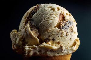 Creamy ice cream scoop filled with chocolate chunks atop a brown cone. The rich texture and contrasting ingredients create an appetizing and indulgent dessert appearance photo
