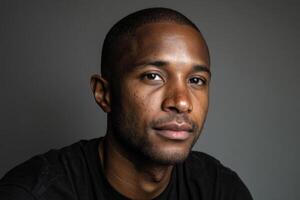 Professional portrait of a man with short hair, wearing a dark shirt, gazing confidently at the camera, with a neutral expression and soft lighting enhancing facial features photo