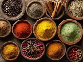 Assorted colorful spices in wooden bowls and cinnamon sticks arranged neatly. Includes turmeric, paprika, curry, star anise, and peppercorns, creating a vibrant, aromatic culinary display photo