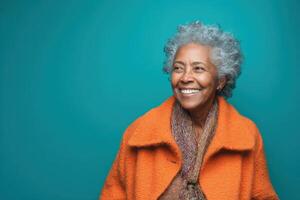 Elderly woman with gray curly hair smiles brightly while looking to her left. She wears an orange coat with a brown scarf. Her joyful expression conveys warmth and happiness photo