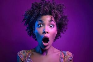 Woman with curly hair has a surprised expression, wide eyes, mouth open. Her colorful patterned top contrasts with dramatic purple lighting highlighting her features photo