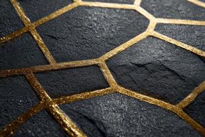 Geometric pattern with black textured stone surface intersected by metallic gold lines, forming hexagonal and polygonal shapes, creating a modern and luxurious appearance photo