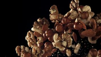 Different types of nuts fly up and fall down. Filmed on a high-speed camera at 1000 fps. High quality FullHD footage video