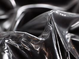 Shiny, crumpled silver material with light reflections creating an abstract and dynamic appearance, featuring smooth curves and textured highlights, evoking a sense of fluid motion photo