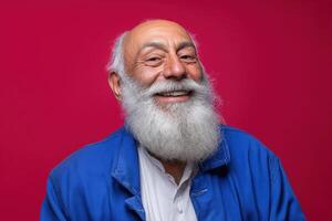 Elderly man with a large white beard smiling broadly, wearing a blue jacket over a white shirt. His expression is cheerful, eyes slightly squinted, with a vibrant pink background photo