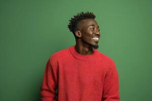 Smiling person wearing a red sweater, looking to the side with a joyful expression. Their hair is styled in a short afro, complementing their confident demeanor. The background is plain photo