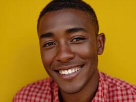 Smiling young man with short hair wearing a red checkered shirt, displaying bright white teeth. Gentle expression and natural look, creating a cheerful and inviting atmosphere photo
