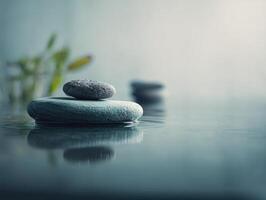 Smooth stones are delicately stacked on a calm water surface with gentle ripples. Soft focus plants are visible in the background, creating a serene and tranquil ambiance photo