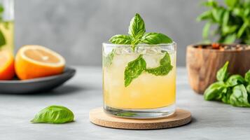 A glass of orange juice with basil leaves and oranges photo