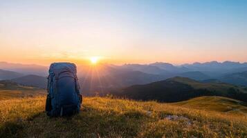 Backpack on mountain top at sunset photo