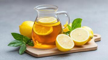 Lemon juice in a jug with lemons on a wooden board photo