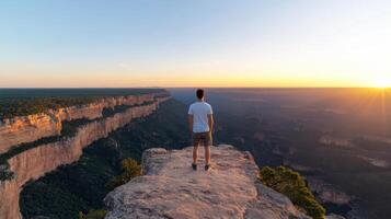 Man standing on edge of grand canyon at sunset photo