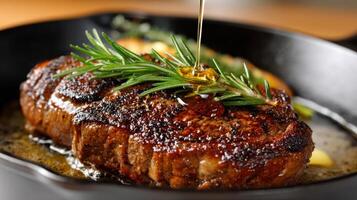 A steak being cooked in a skillet with rosemary photo