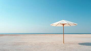An umbrella on a sandy beach with blue sky photo