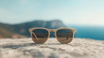 A pair of sunglasses on top of a rock photo