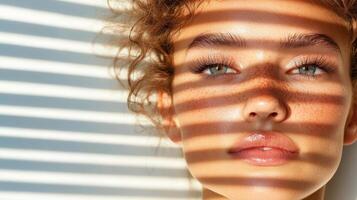 A woman with freckles and a sunburn is looking at the camera photo