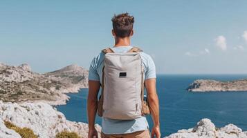 Man with backpack looking out over the ocean photo