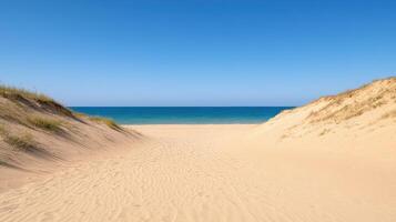 A sandy beach with sand dunes and blue water photo