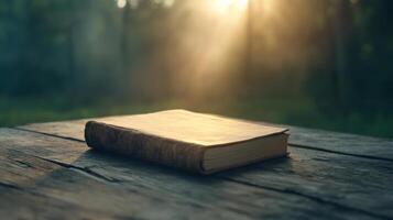 An old book on a wooden table in the woods photo