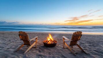 Two chairs sit on the beach with a fire pit in the background photo
