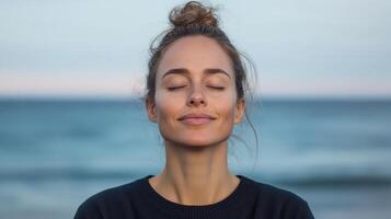 A woman is meditating on the beach photo