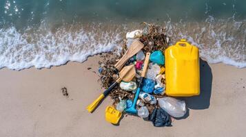 Pile of plastic debris, including paddles and containers, washed up on beach near ocean waves photo