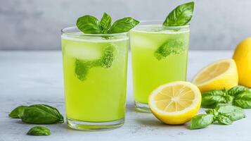 Two glasses of lemonade with basil leaves photo