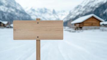 A wooden sign in the snow with a cabin in the background photo